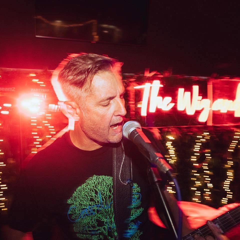 John playing guitar with 2HD under red club lighting